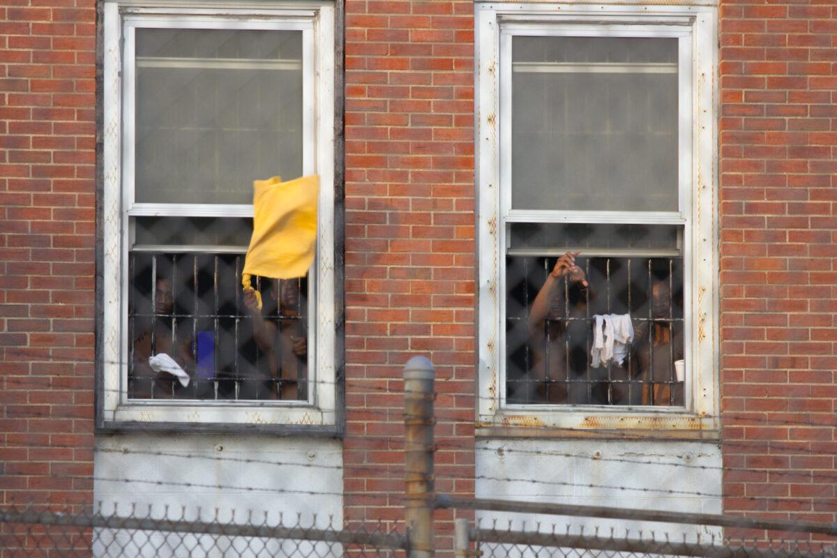 prisoners wave shirts outside the windows of the Workhouse prison in St. Louis