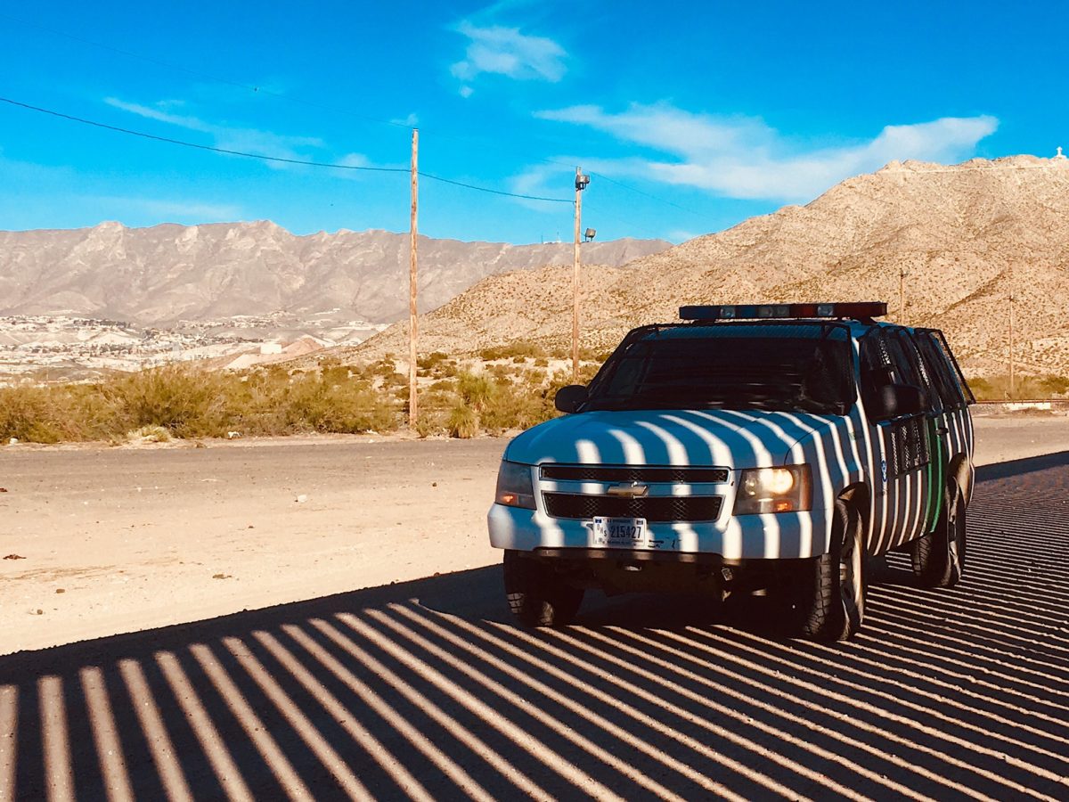 Image of border patrol truck in shadow of border wall in Sundland Park, NM