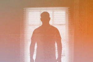 Image of man against window.