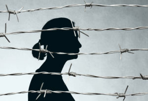 Woman Prisoner Behind Barbed Wire