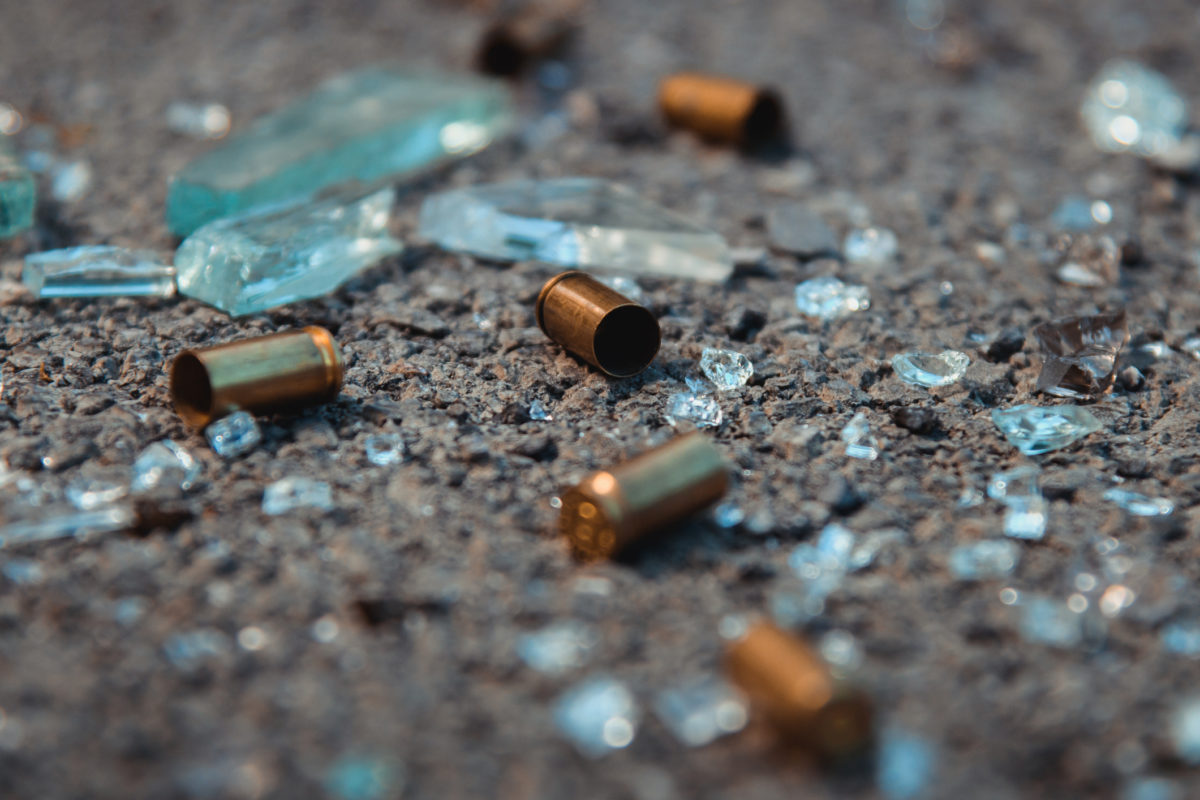 bullet casings and broken glass on a street