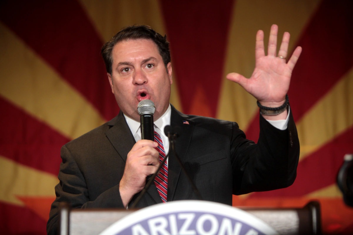 Arizona Attorney General Mark Brnovich stands at a lectern.