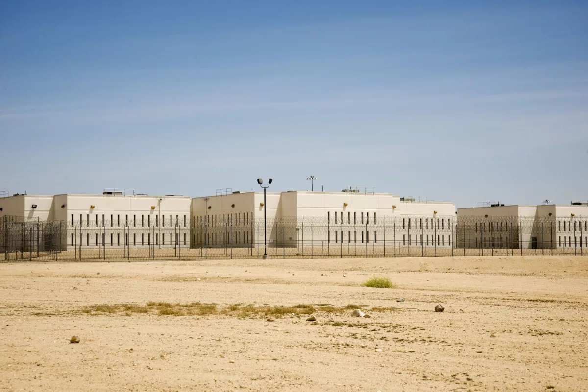 This photo shows California City Correctional Center, a stark, beige prison, sitting in the middle of empty desert as the sun beats down.