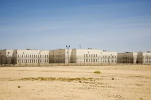 This photo shows California City Correctional Center, a stark, beige prison, sitting in the middle of empty desert as the sun beats down.