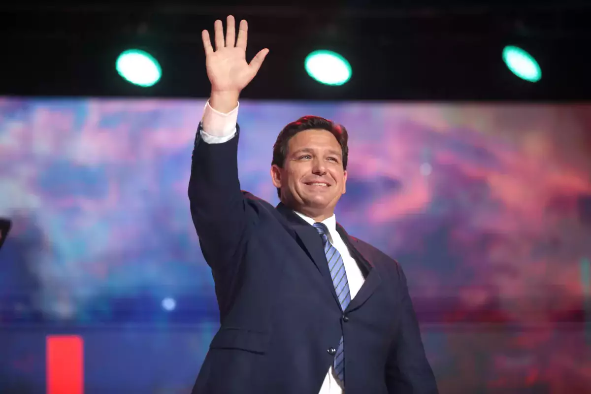 This photo shows Ron DeSantis waving at a crowd on a stage.