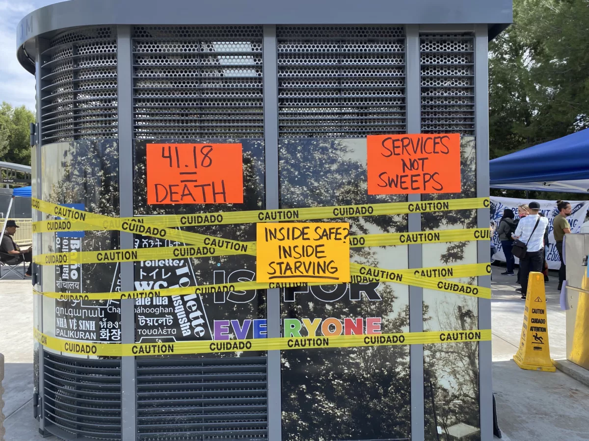 This shows anti-homeless-sweep signs at the Aetna Street encampment, includuing a sign that reads, "Inside Safe? Inside Starving!"