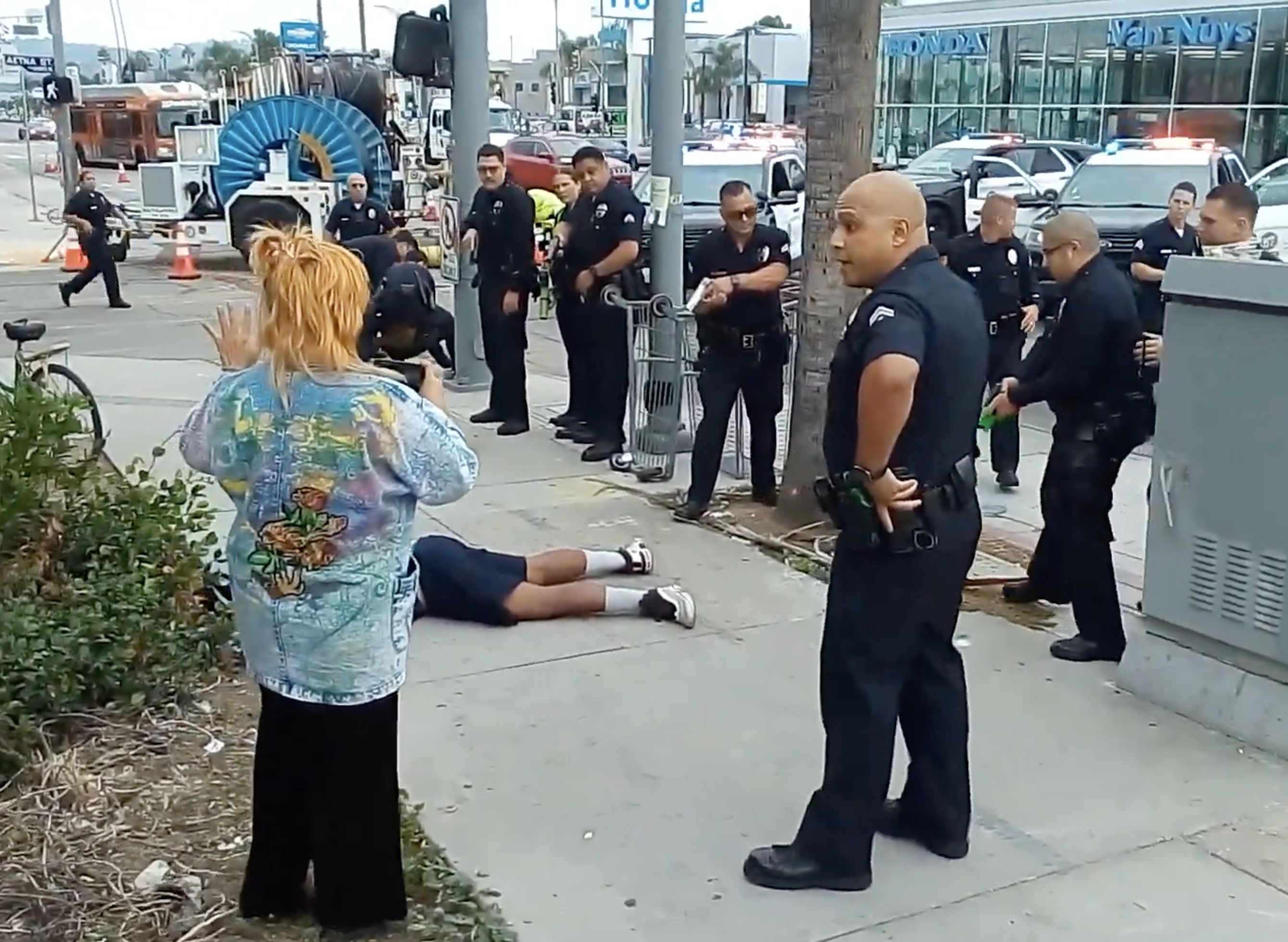 This photo shows four officers pointing their guns at members of an unhoused persons' encampment in Van Nuys, California.