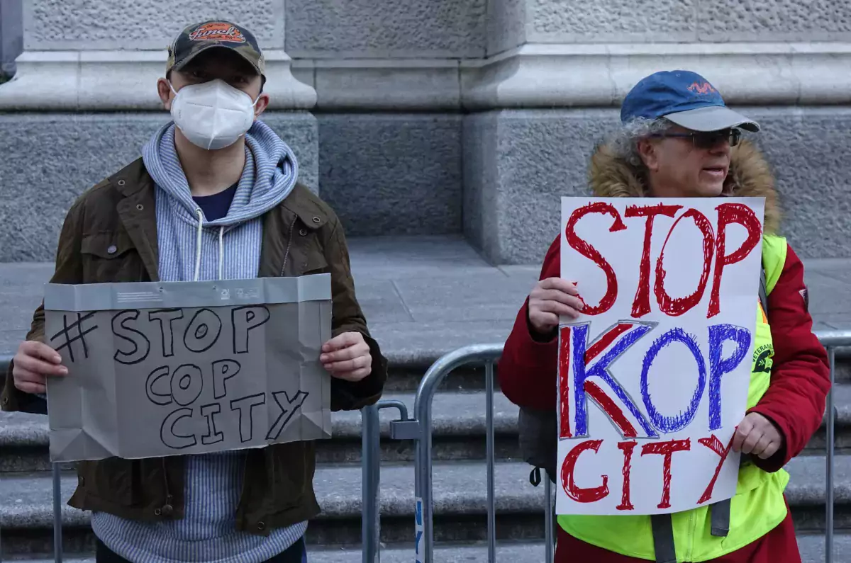 This photo shows two people holding "Stop Cop City" protest signs outdoors. Georgia has passed a bill effectively banning bail funds amid the protests.