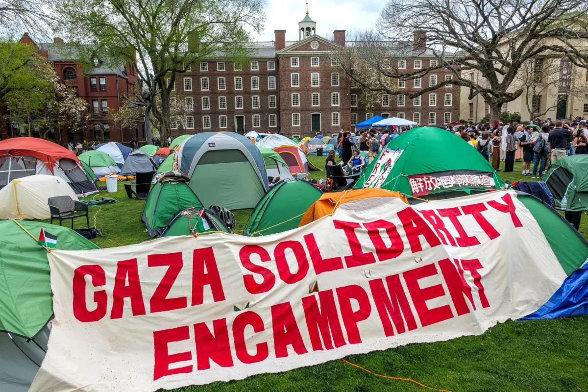 This photo shows tents on a lawn at Brown University. A large sign says "Gaza Solidarity Encampment."