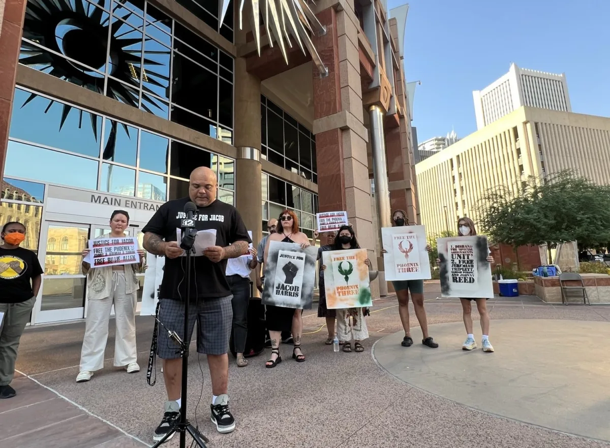Roland Harris and several others stand outside Phoenix City Hall during a press conference.