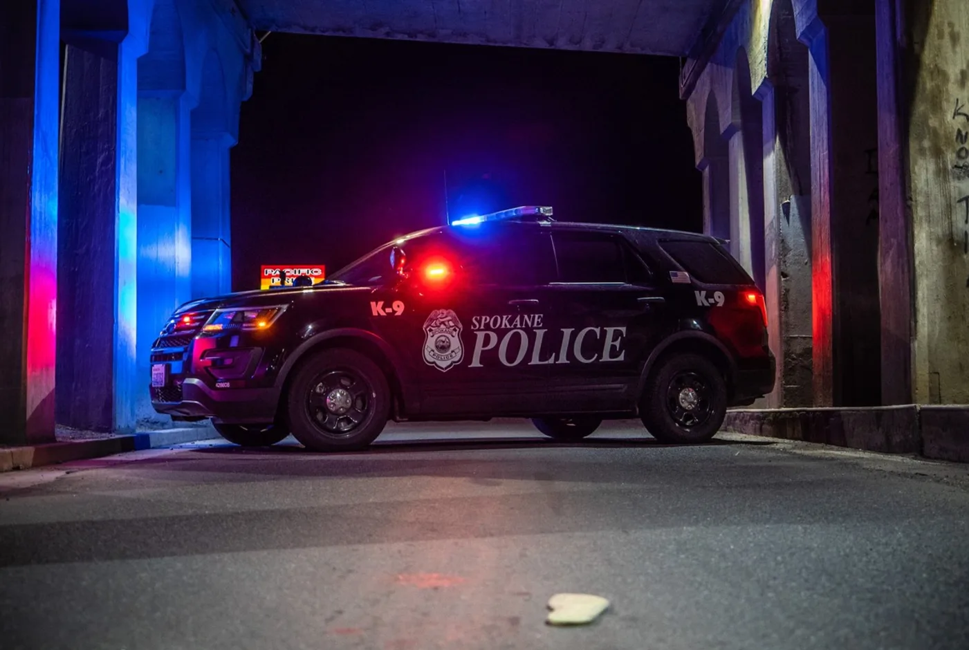 This photo shows a Spokane Police Department cruiser with its lights on at night.