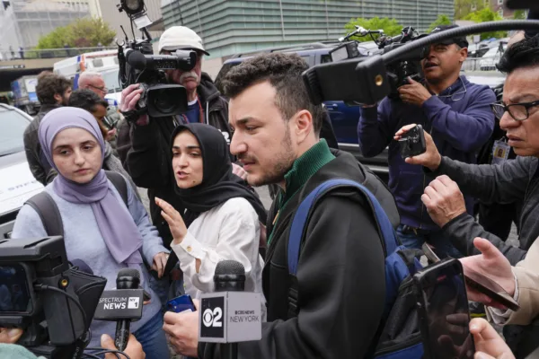 Members of the Columbia University Apartheid Divest group, including Sueda Polat, second from left, and Mahmoud Khalil, center, are surrounded by members of the media outside the Columbia University campus, Tuesday, April 30, 2024, in New York