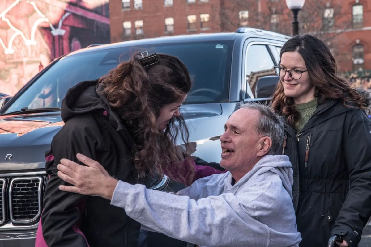 James Carver embraces his ex-wife, Mary Jane Dempsey, while their daughter, Kaitlyn Verzi, smiles.